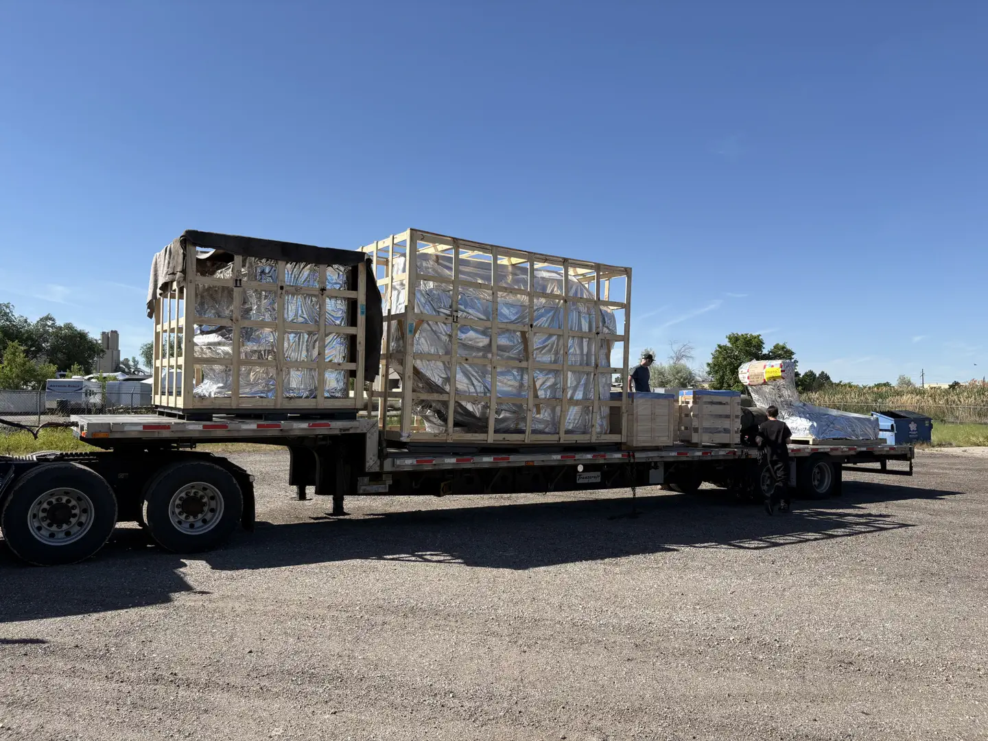 Crated cargo being loaded onto a flatbed trailer